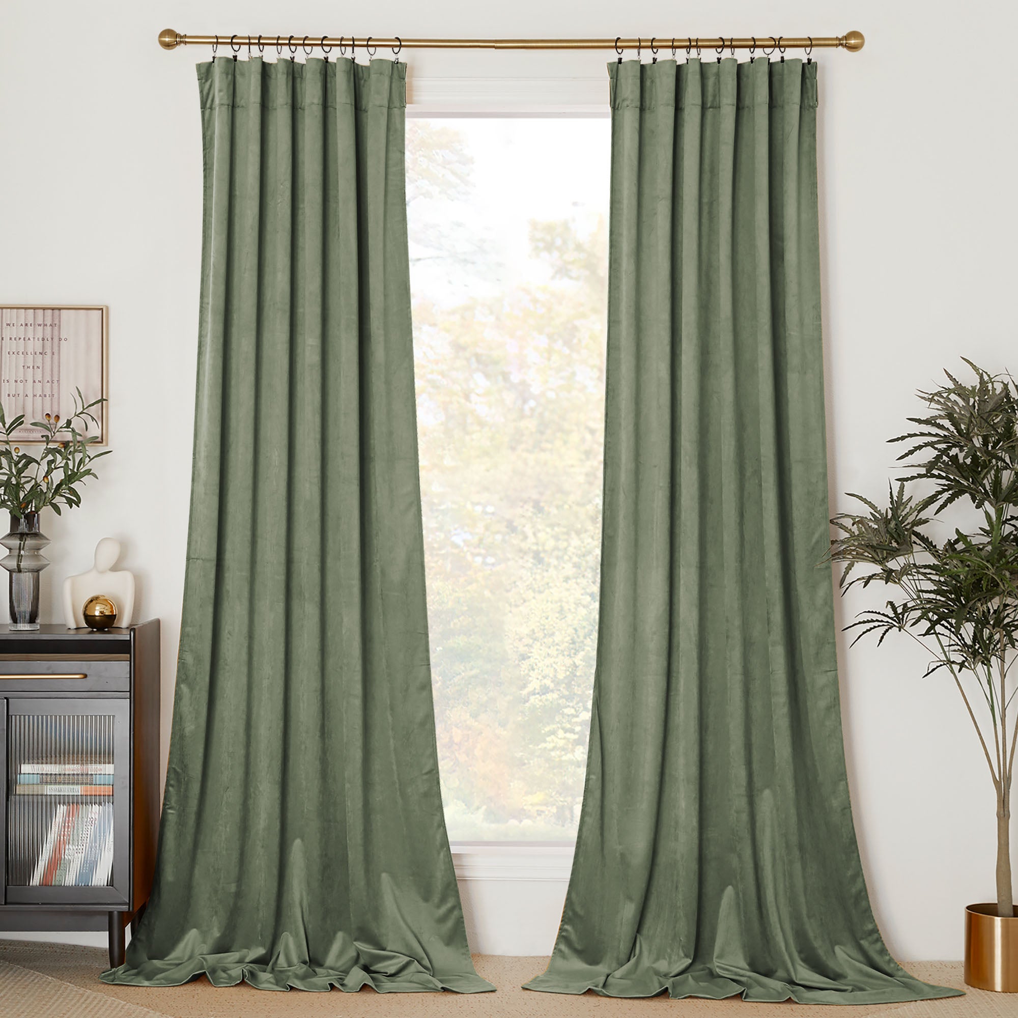 A pair of floor-length sage green velvet curtains hang on a brass rod, framing a window in a modern living room.