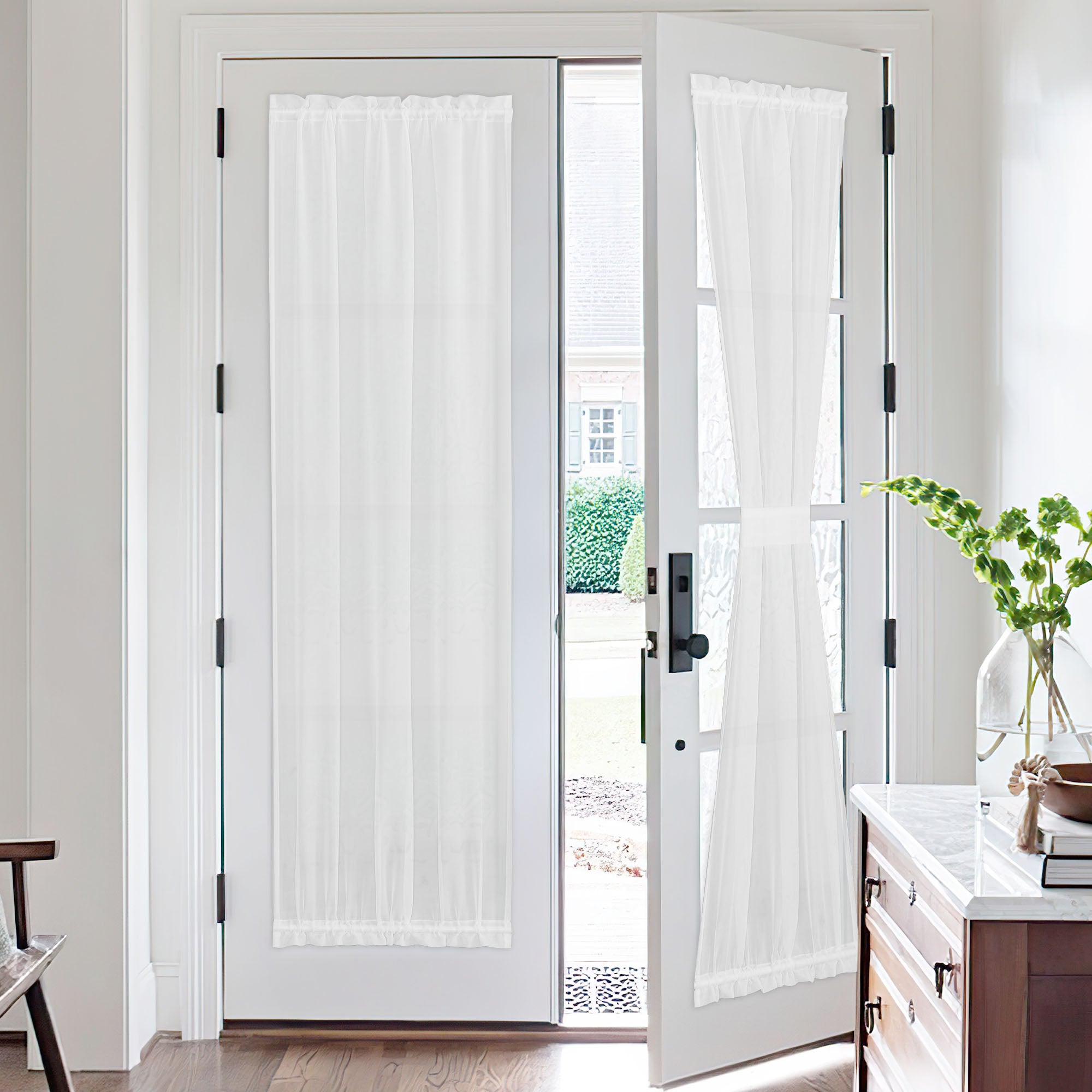 White voile sheer door curtains on French doors; one curtain is tied back, offering soft light and privacy.
