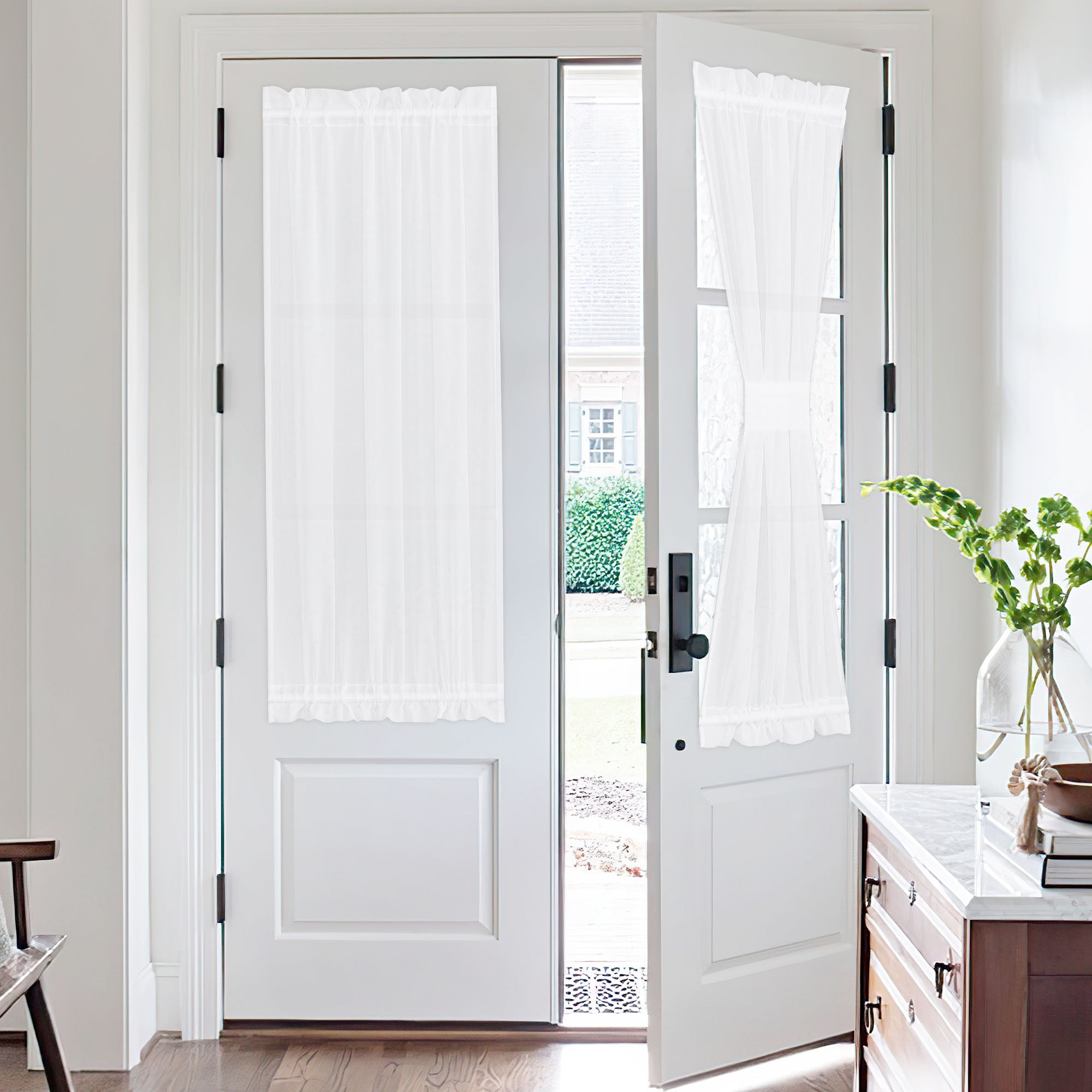 White voile sheer door curtains installed on double French doors, one curtain beautifully tied back for light control and style.