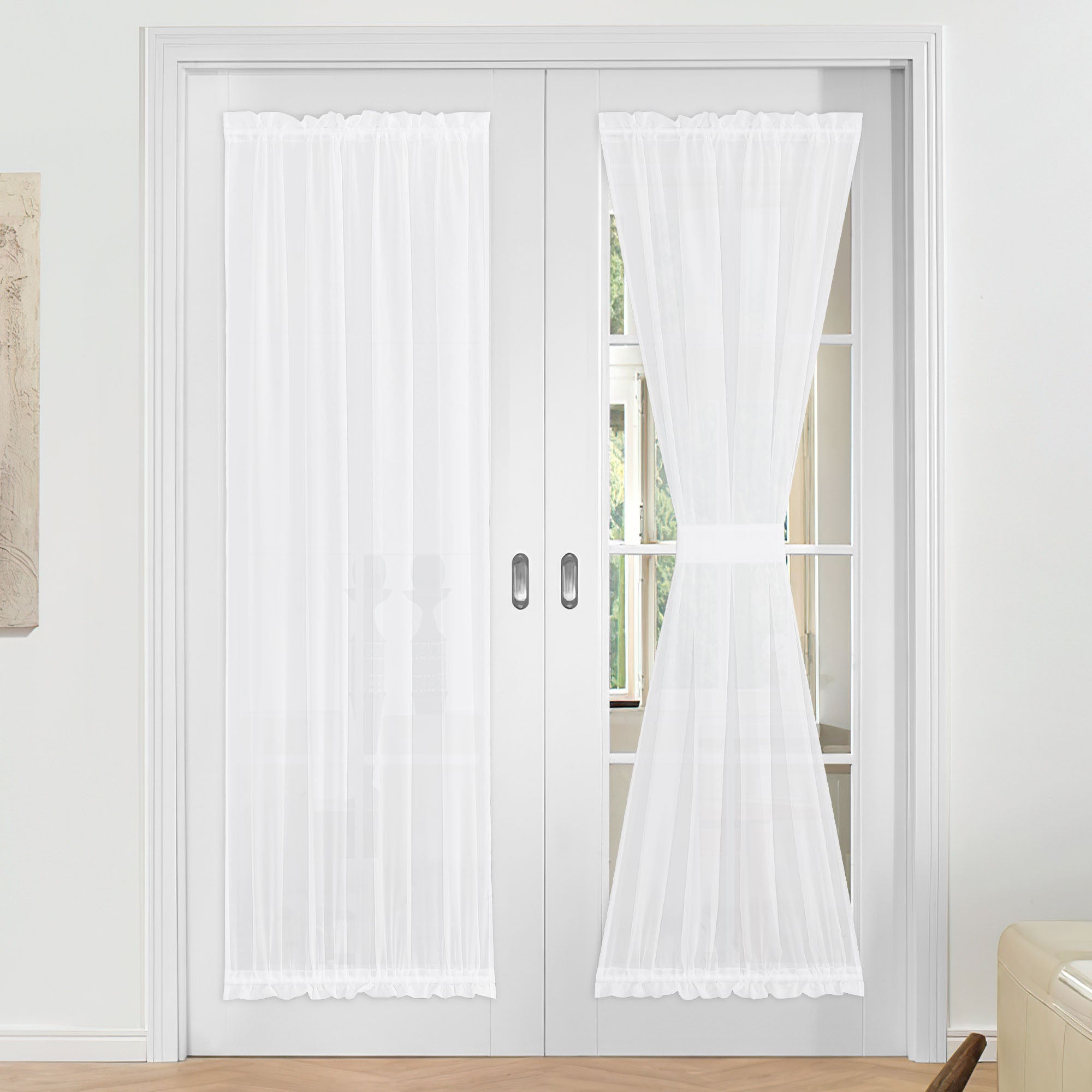 White ruffled voile sheer door curtains on French doors, one panel elegantly tied back, for privacy and light.