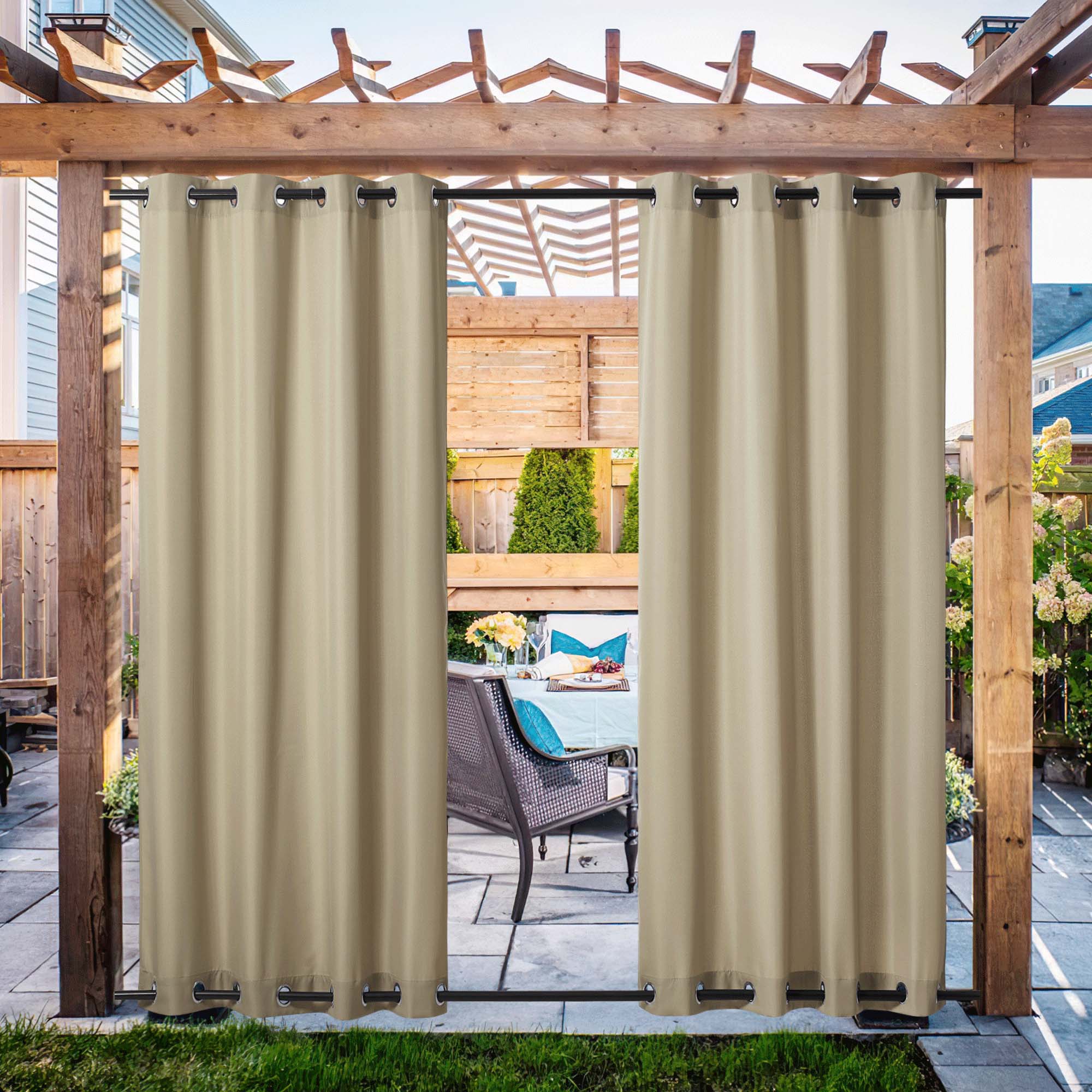 Beige waterproof canvas outdoor curtains hung on a wooden pergola, partially open to reveal a patio dining setup. Features top & bottom grommets.