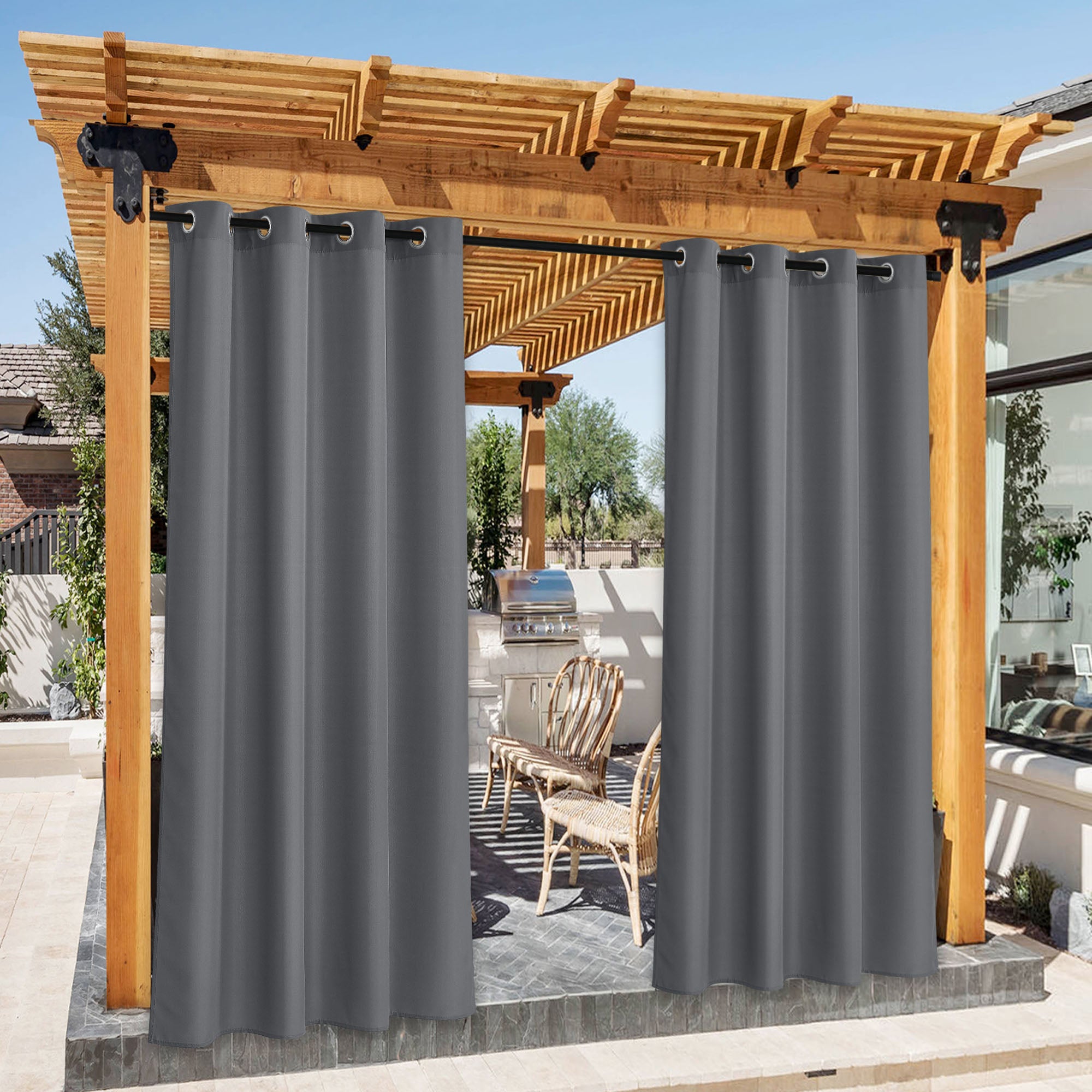 Dark grey waterproof canvas outdoor curtains with grommets on a wooden pergola, open to a patio BBQ area.