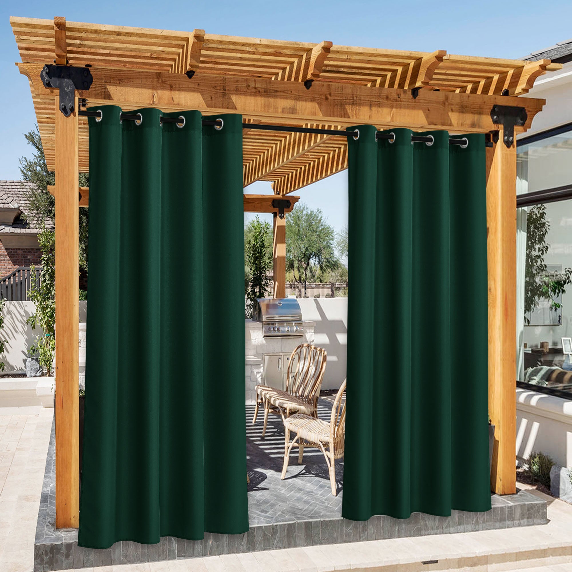 Dark green waterproof canvas outdoor curtains hanging on a wooden pergola, partially open to reveal a patio area.