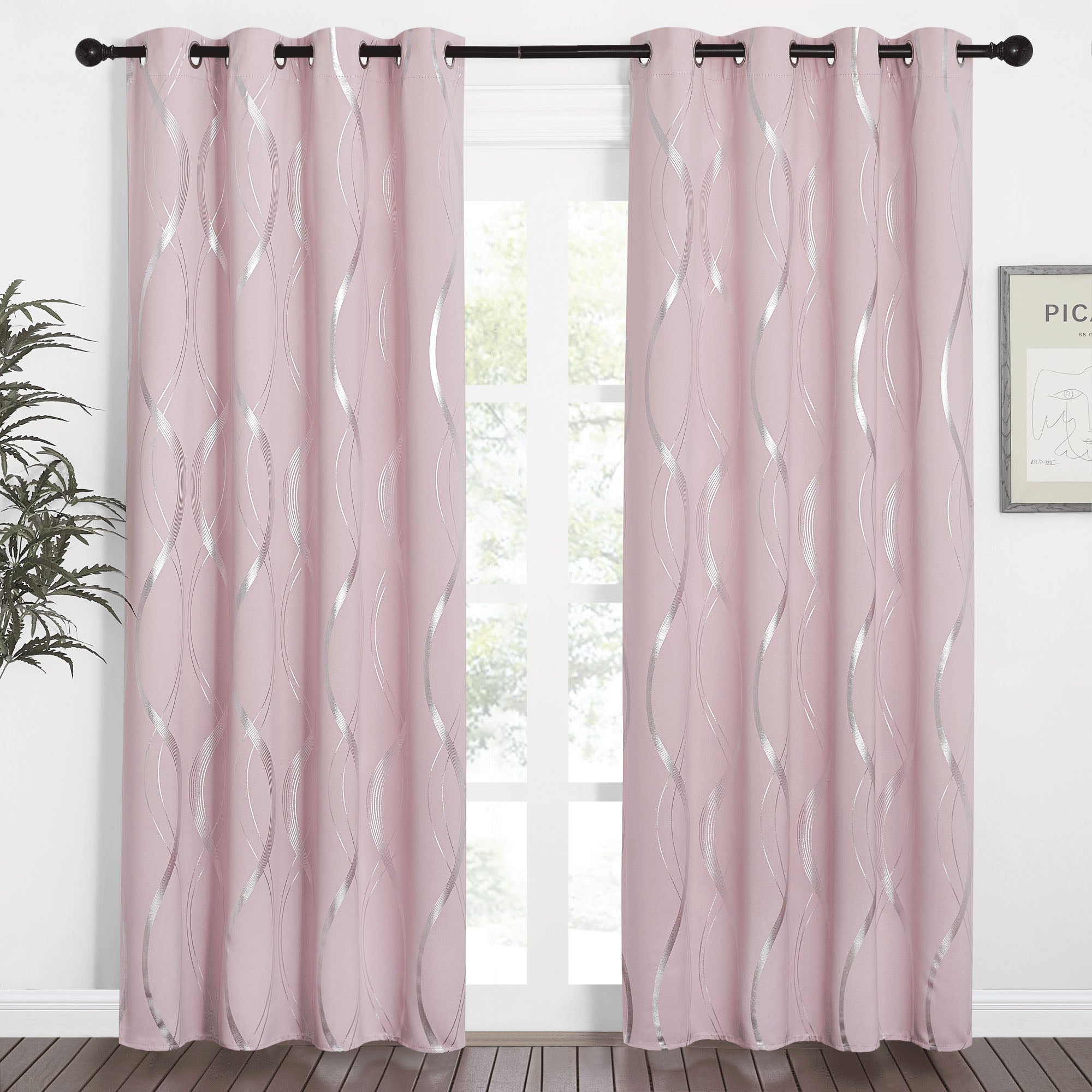 Elegant pink blackout curtains with a stylish silver wave line pattern, grommet top, hung on a rod framing a window.