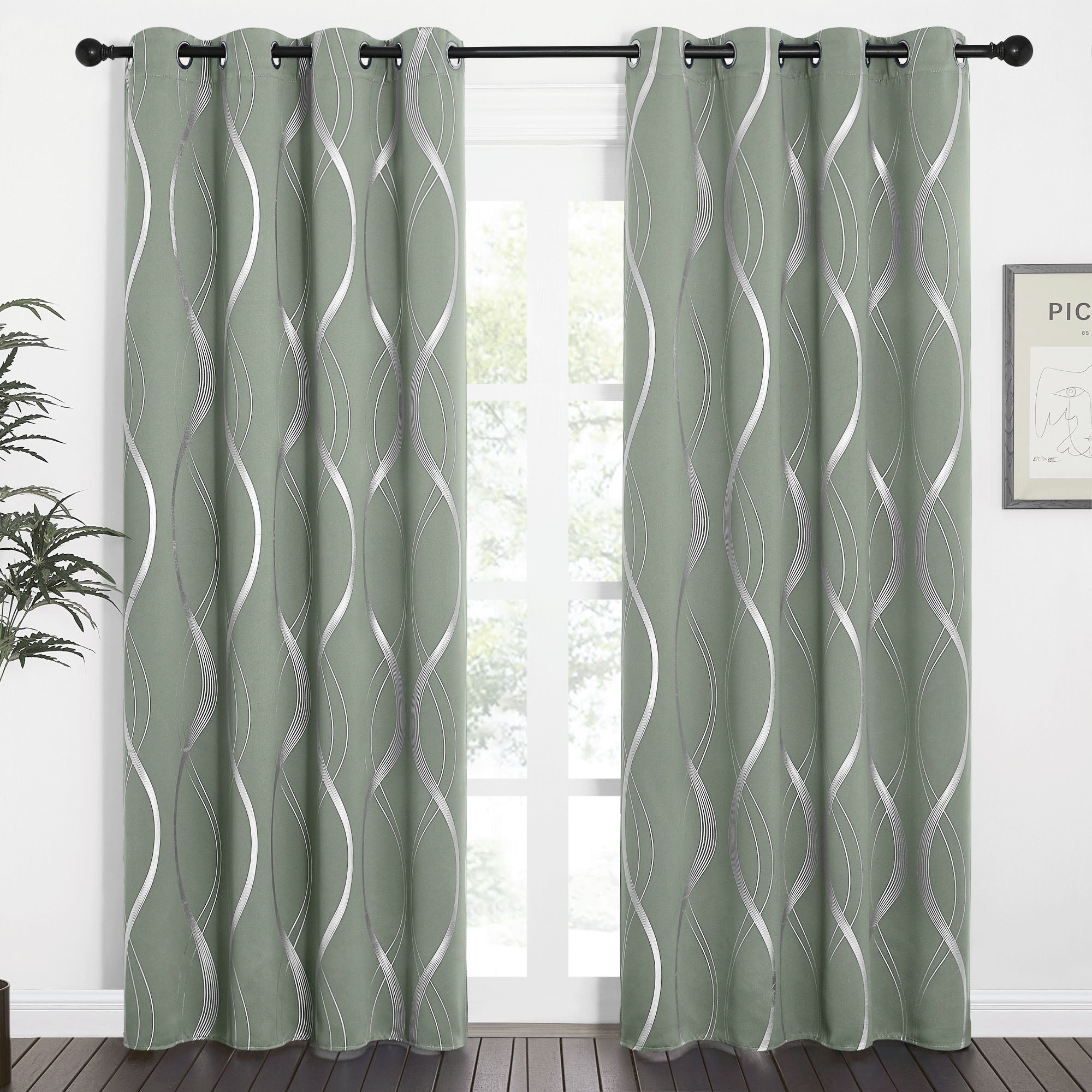 Sage green wave line blackout curtains with silver metallic pattern, hung on a black grommet rod.