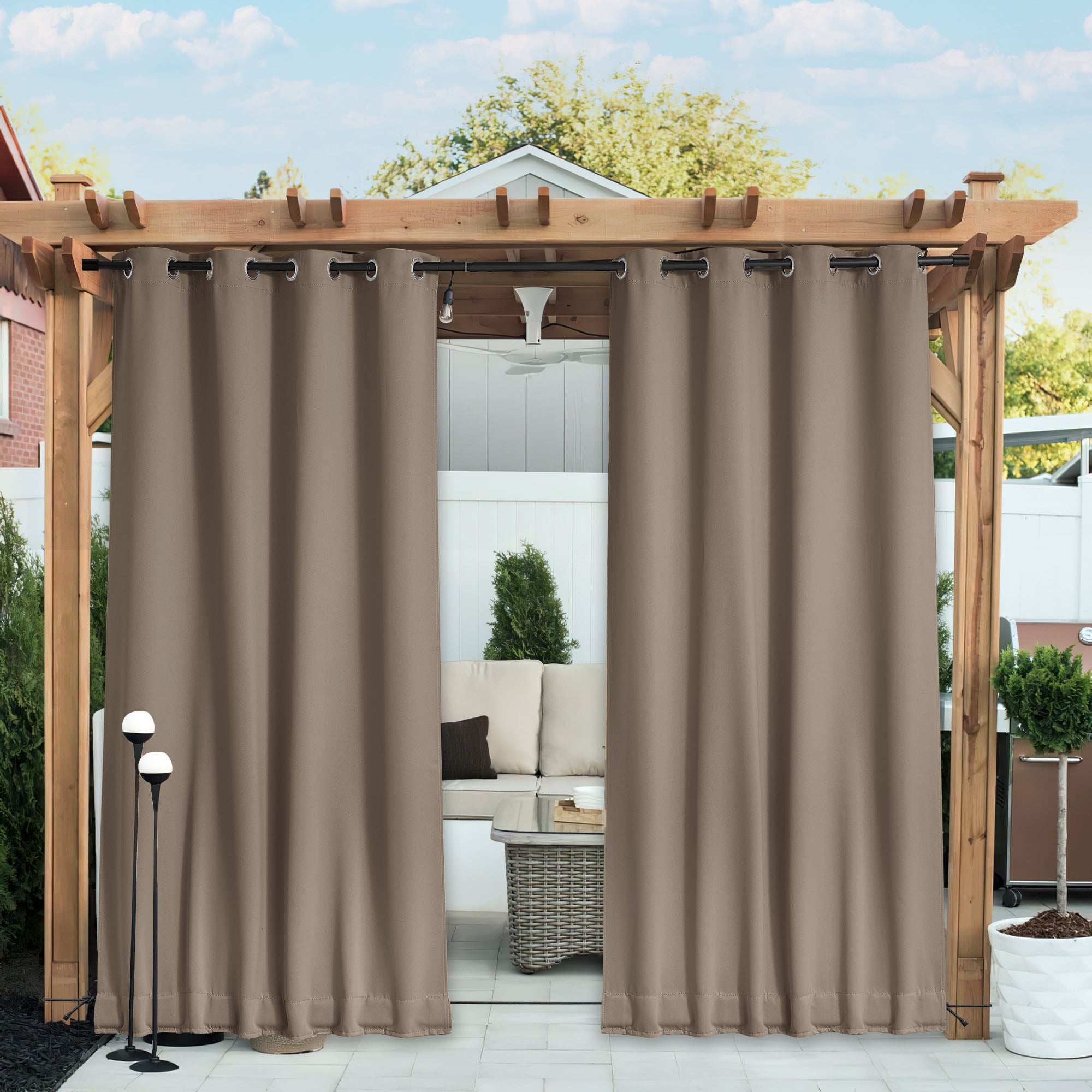 Brown waterproof blackout outdoor curtains on a wooden pergola, partially open over a patio seating area.