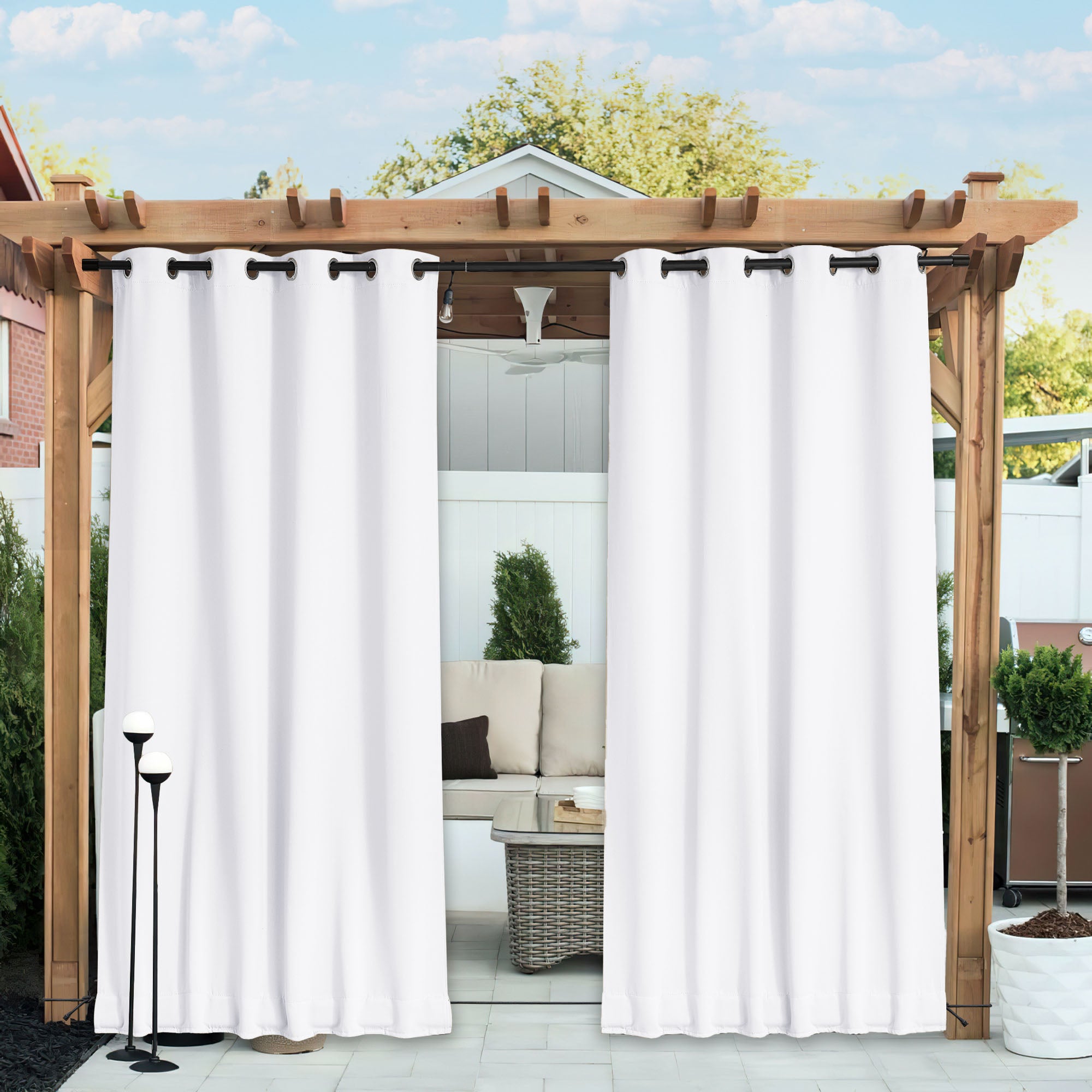 White waterproof blackout outdoor curtains with grommets on a black rod, partially open under a wooden pergola.