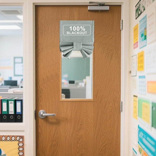 Light grey 100% blackout door window shade with pleated bottom, mounted on a wooden office door.