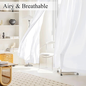 Airy white sheer curtains gently blowing indoors in a bright modern room, enhancing natural light and softness.