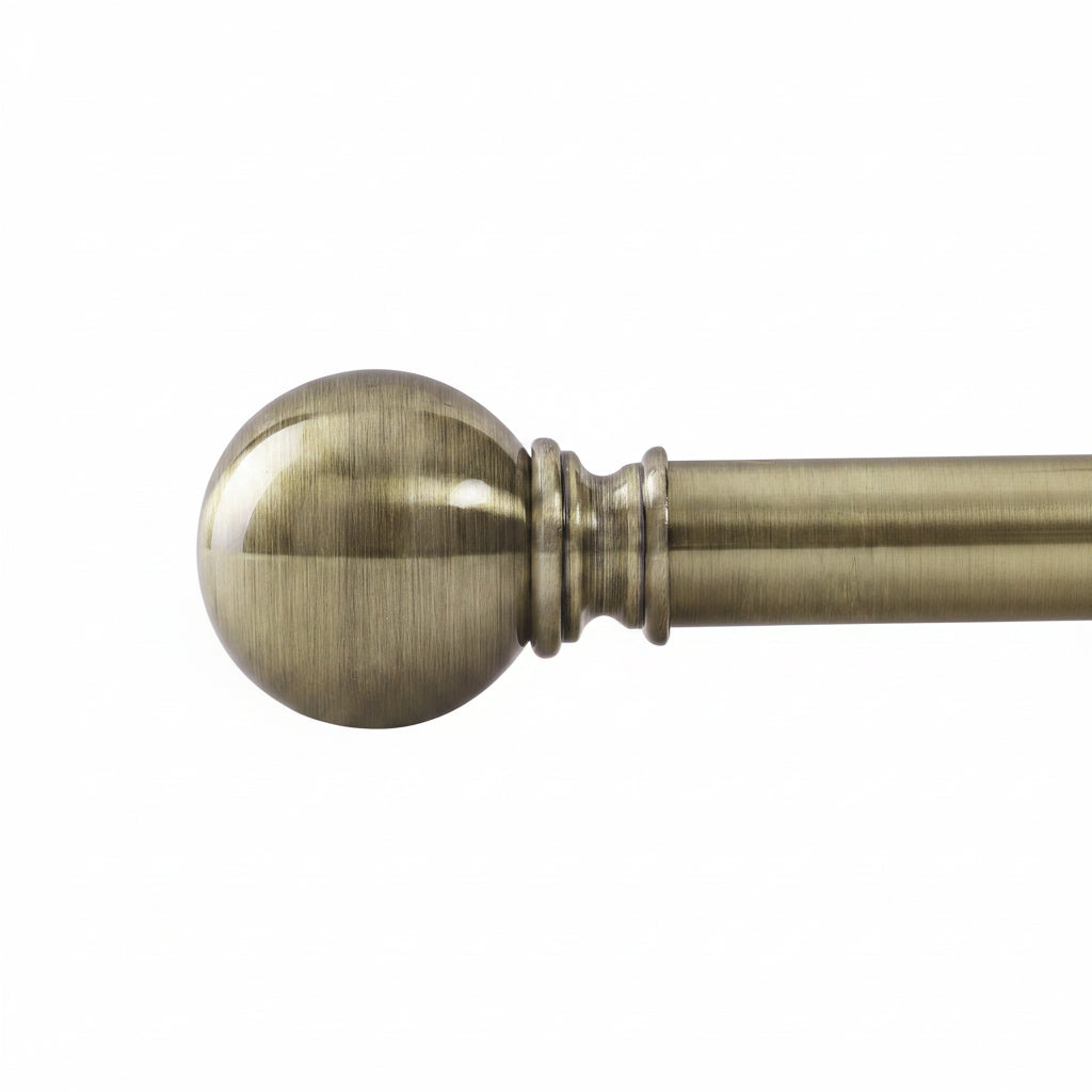 Antique brass curtain rod with polished sphere finial shown in close-up
