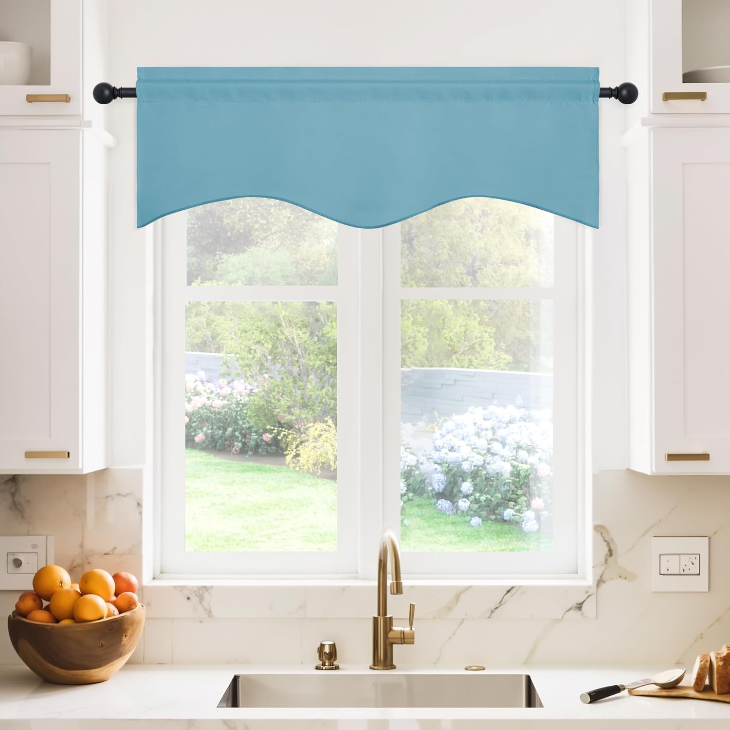 Aqua blue scalloped window valance on a black rod above a kitchen sink with a garden view.