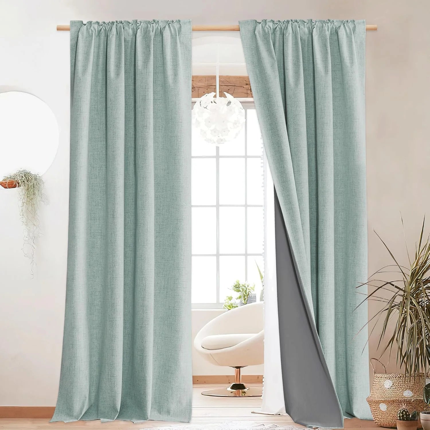Light aqua linen-look blackout curtains on a wooden rod in a bright modern room