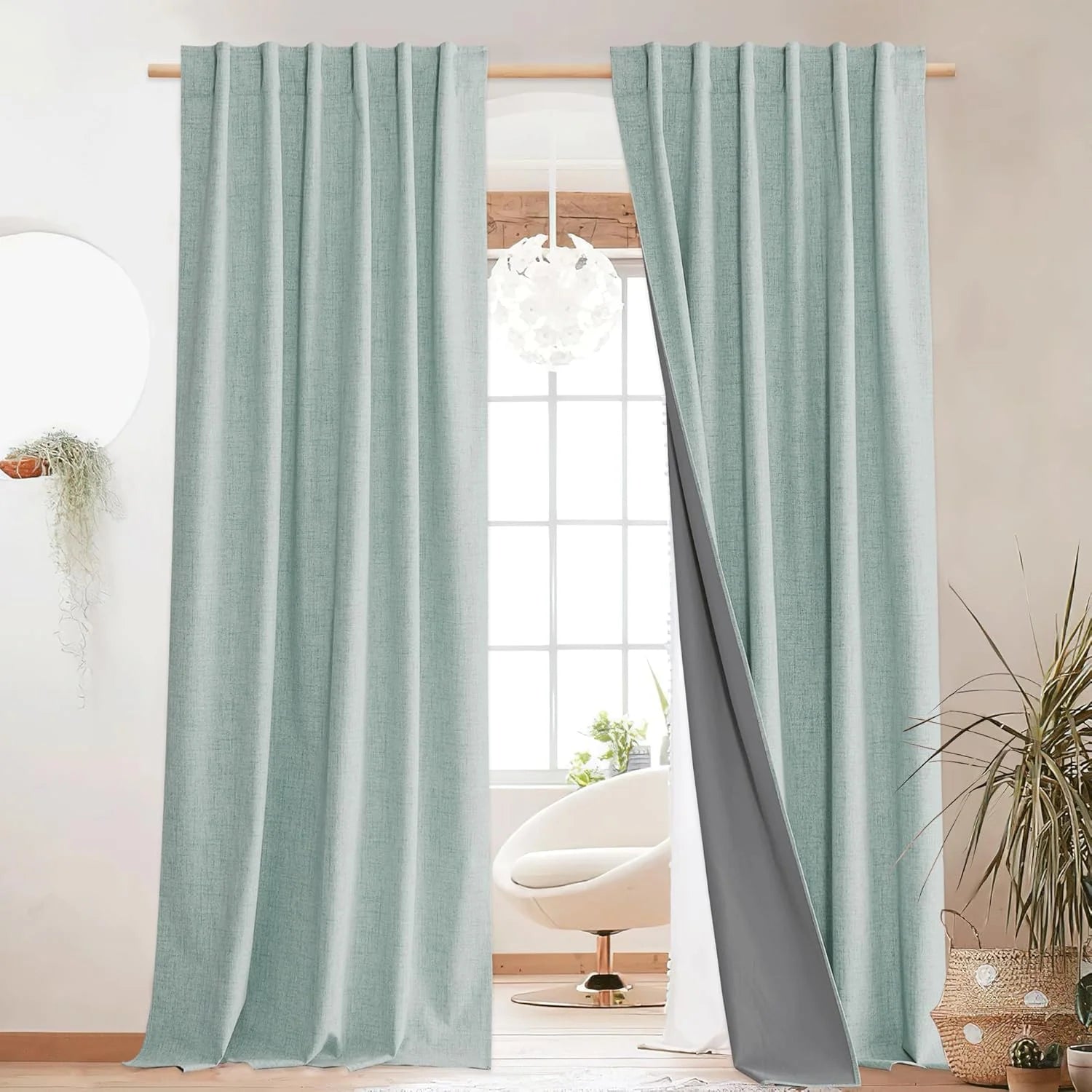 Light aqua linen-look blackout curtains on a wood rod in a bright modern room