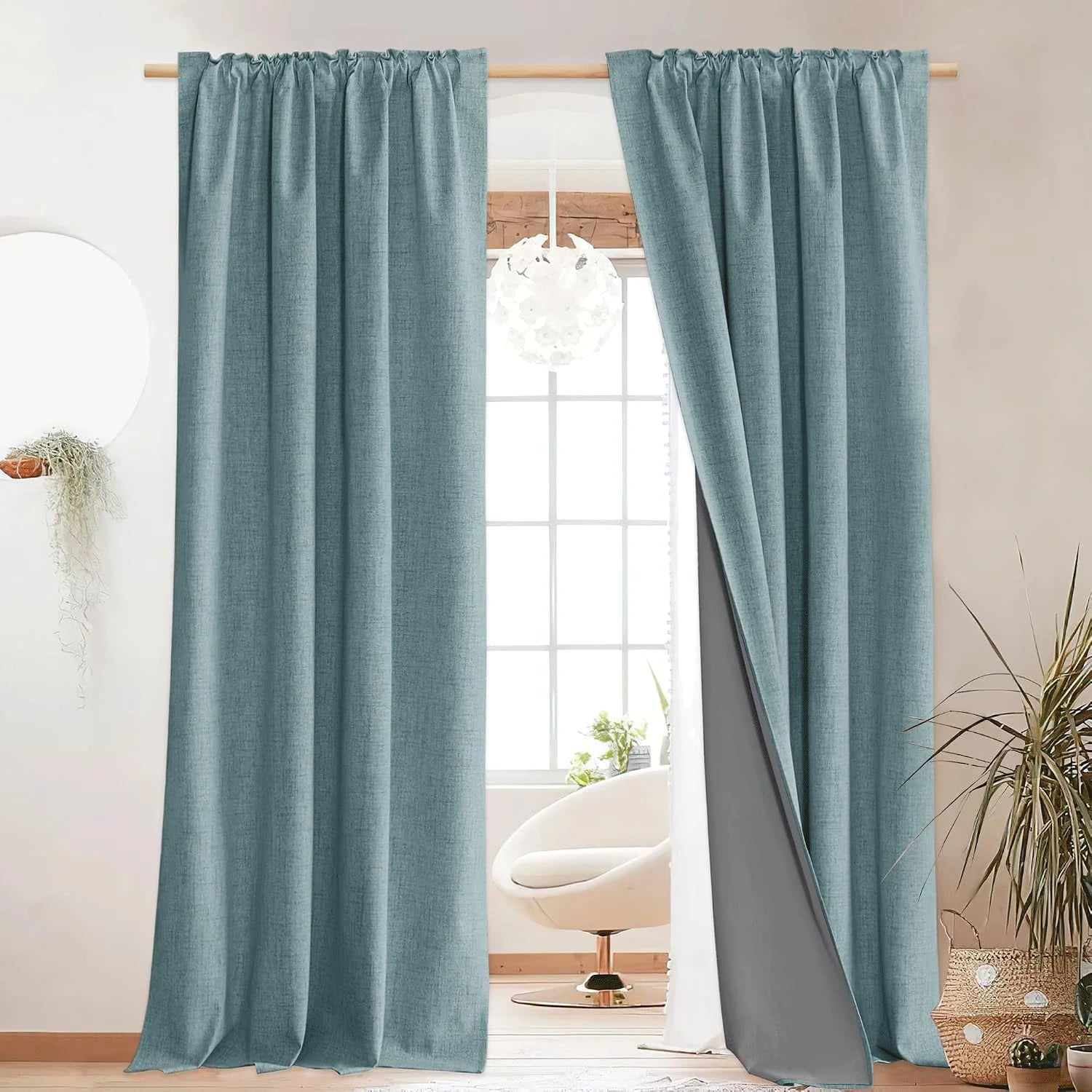 Aqua linen-look blackout curtains on a wooden rod in a bright modern room