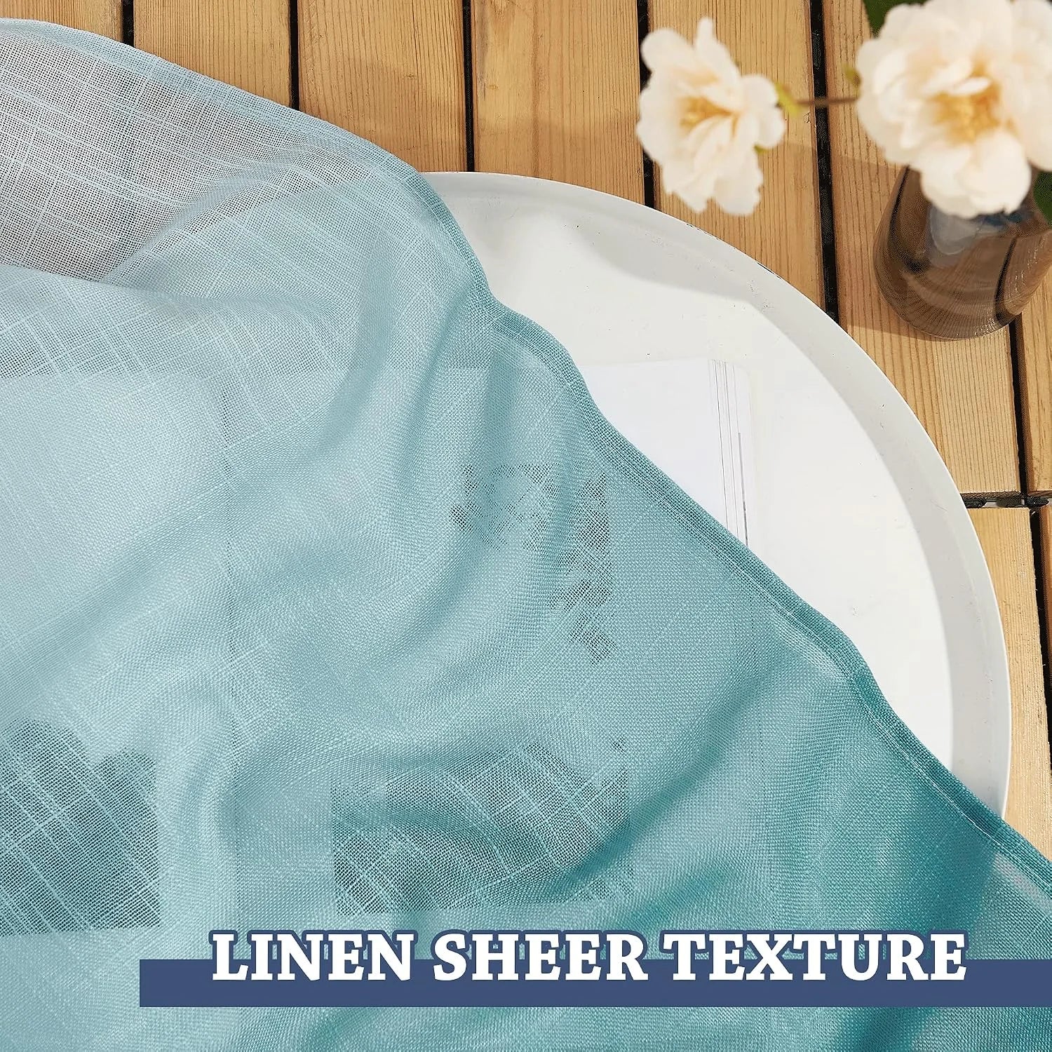 Light aqua sheer linen-texture curtain fabric draped on a white tray over wood slats