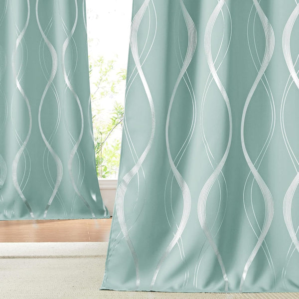 Pair of aqua curtains with shiny silver metallic wavy geometric pattern in a bright room.