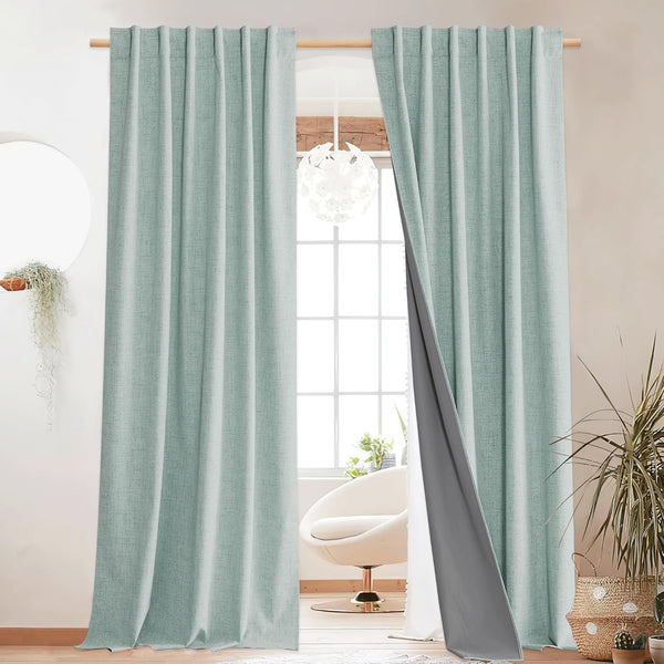 Textured aqua thermal blackout curtains with visible grey backing, hanging on a wooden rod.