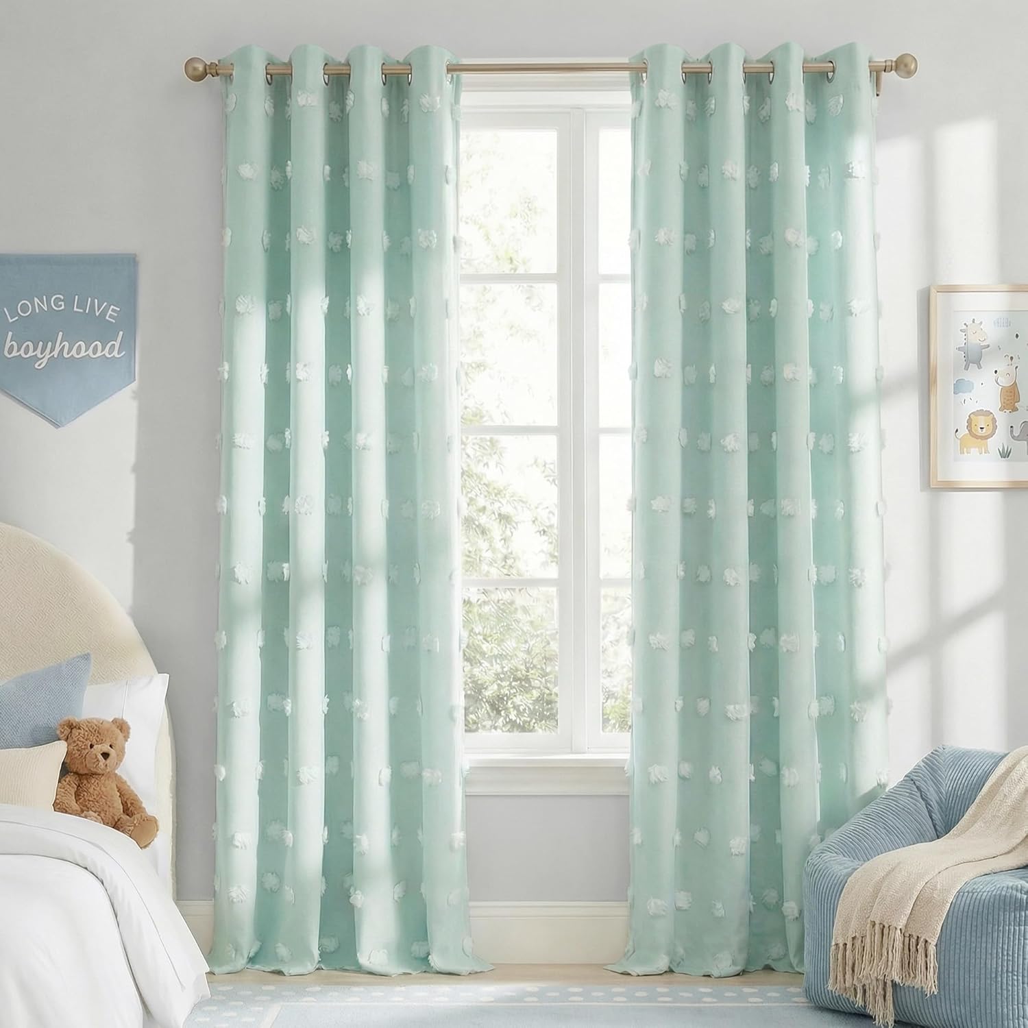 Seafoam green sheer curtains with white pom-pom tufts and bronze grommets in a bright bedroom.