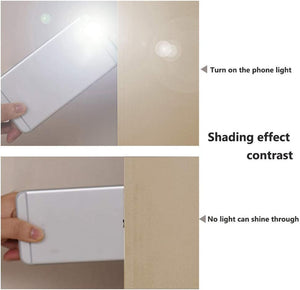 Beige blackout fabric light-blocking test, showing complete shade against bright phone flashlight.