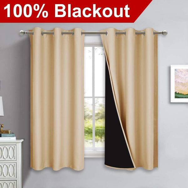 Beige blackout curtains with silver grommet tops on a rod over a window. Black lining visible.