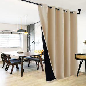 Beige thermal blackout grommet curtain with black lining, dividing a modern dining space.