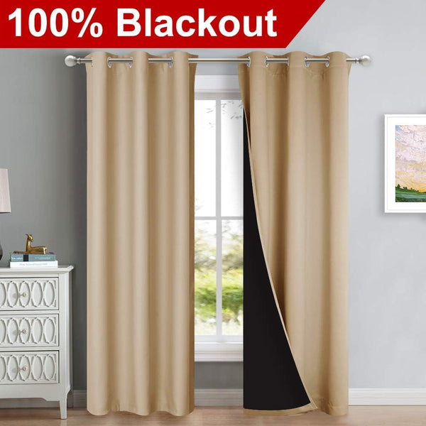 Beige blackout curtains with silver grommet top hanging. One panel reveals black thermal lining inside.