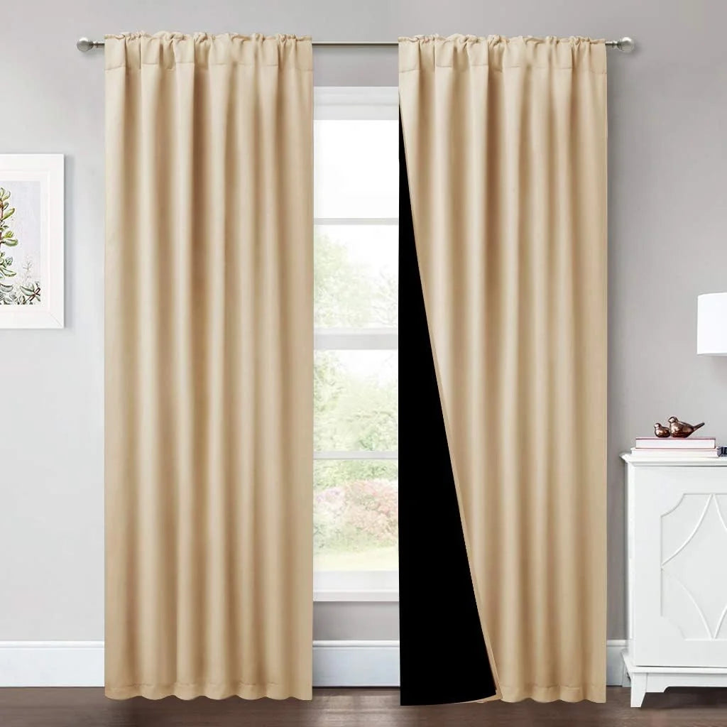 Beige blackout curtains on a silver rod in a bright modern room with one panel pulled back