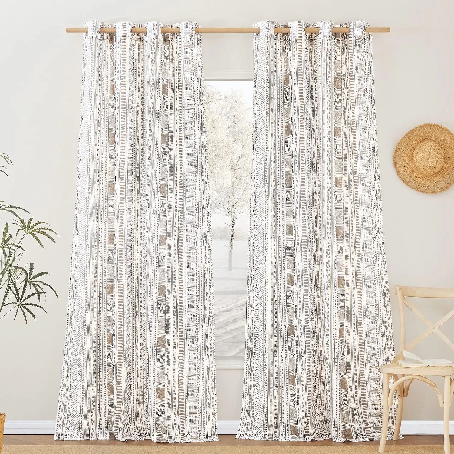 Beige boho geometric curtains on wooden rod in a bright neutral room