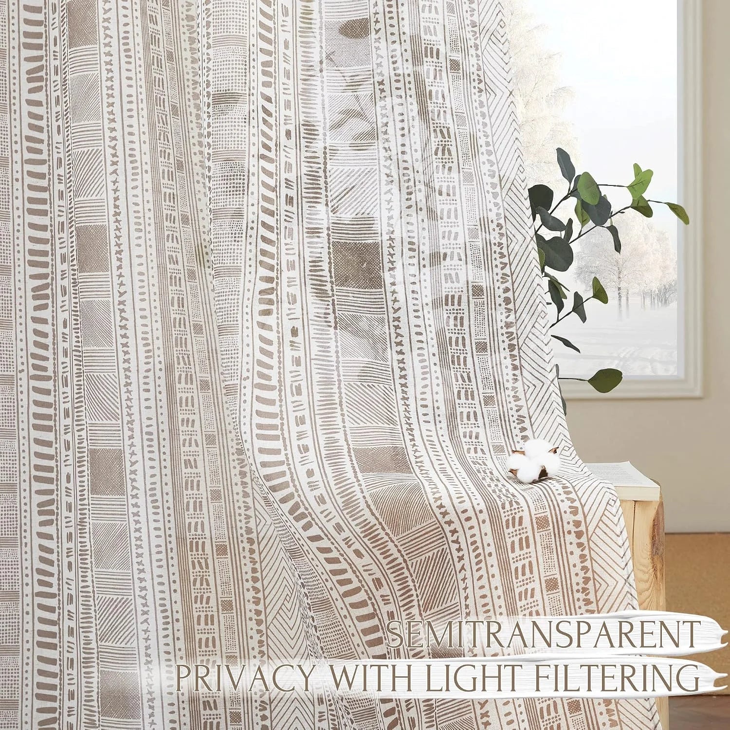 Beige semi-sheer curtain with tribal geometric print filtering light by a window