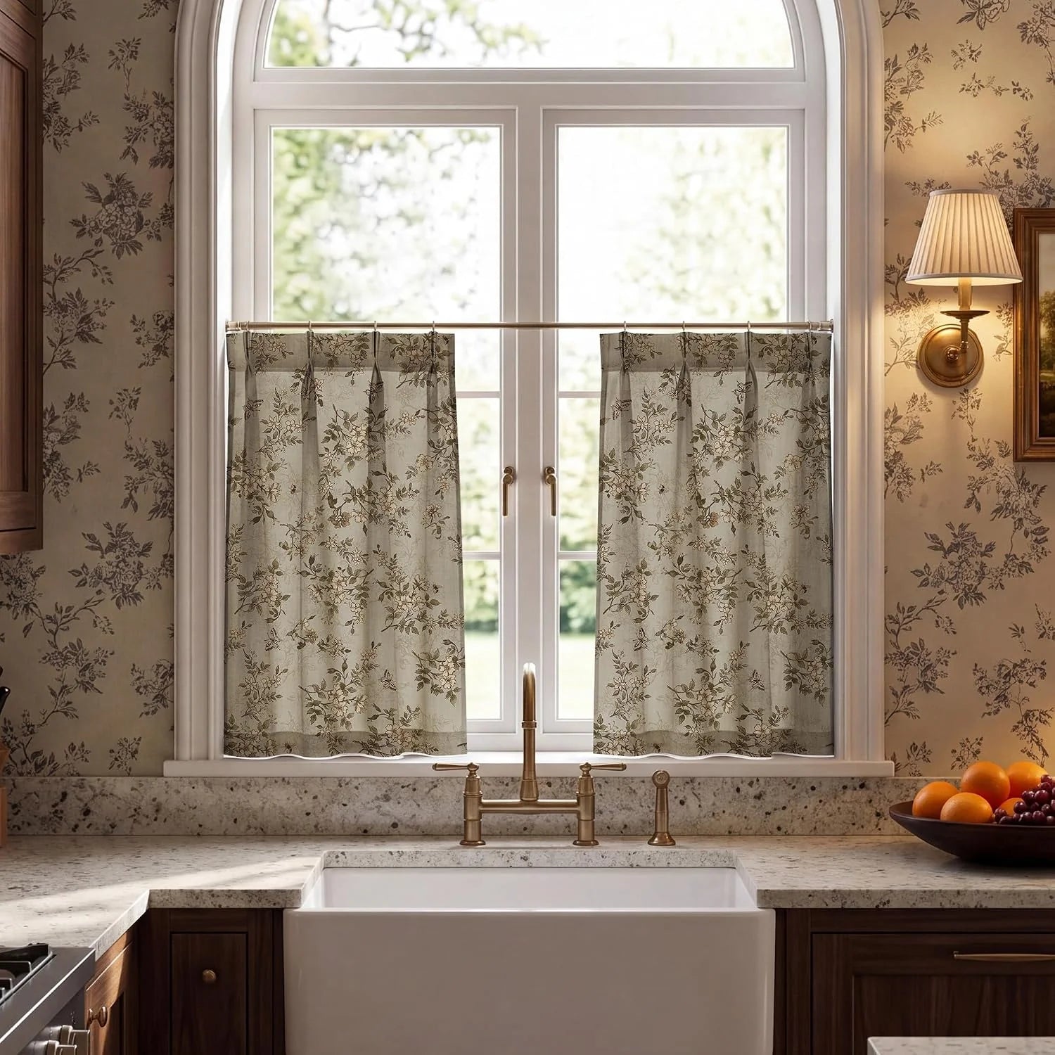Beige floral cafe curtains on a brass rod over an arched kitchen sink window