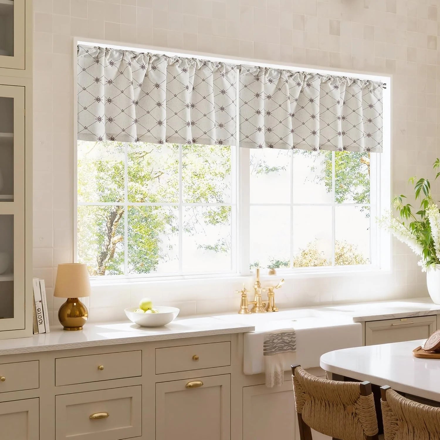 Beige geometric kitchen valance over double windows in a bright modern farmhouse sink area