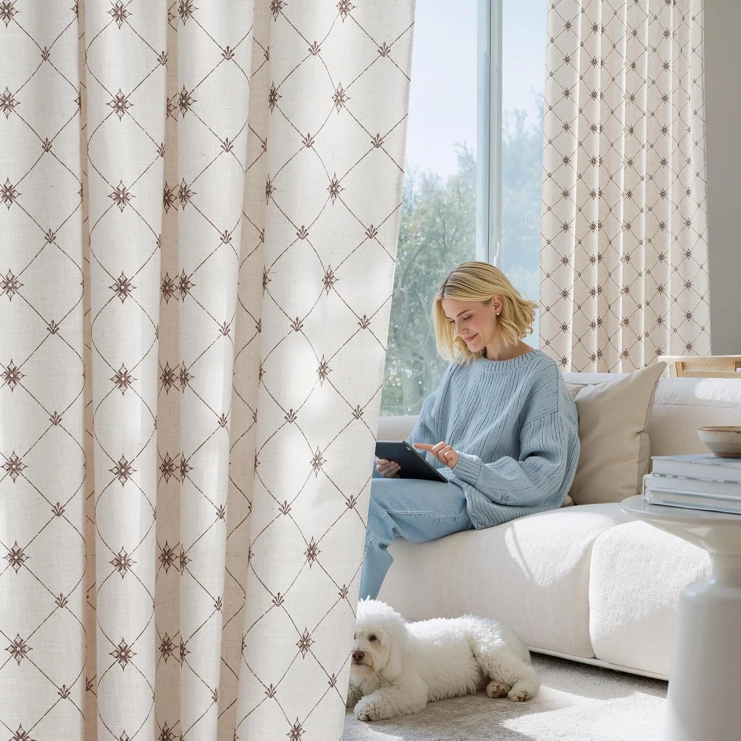 Beige geometric patterned curtains in a bright living room with woman on sofa
