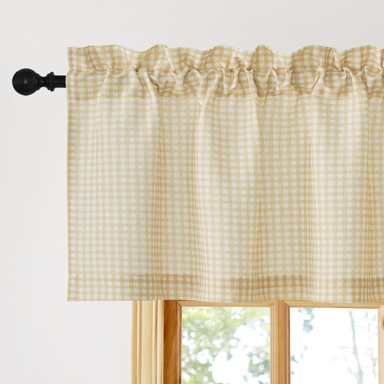 Beige and off-white gingham pattern rod pocket valance hanging on a black curtain rod above a wooden window.