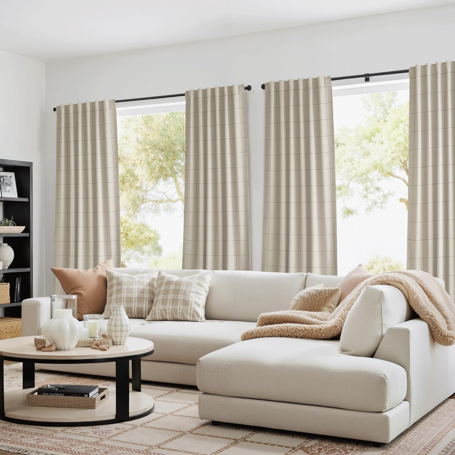 Light beige window drapes with a subtle grid pattern hanging from a black rod in a modern living room