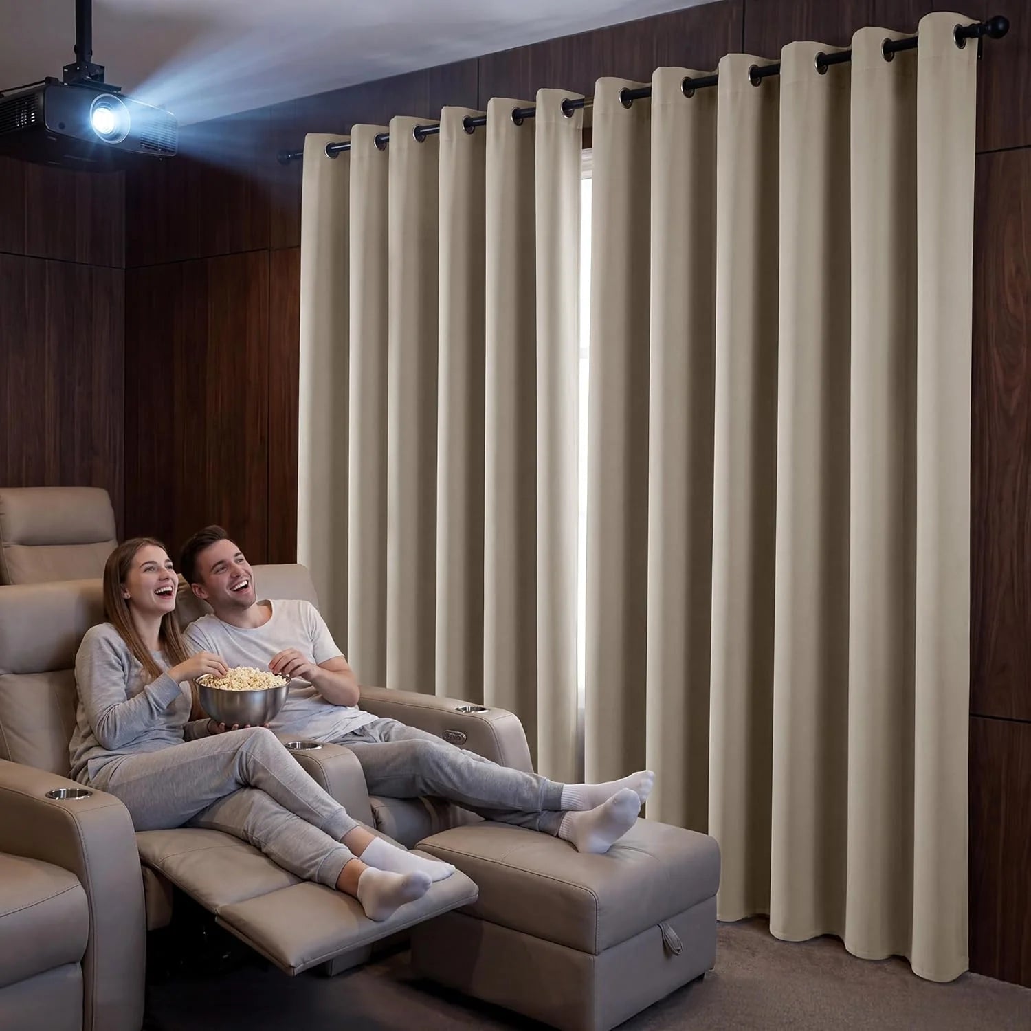 Beige grommet blackout curtains in a home theater with a couple watching a movie.
