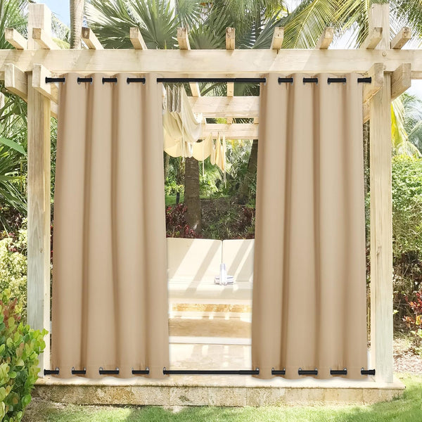 Beige grommet top and bottom outdoor curtains hanging on a wooden pergola in a sunny setting.
