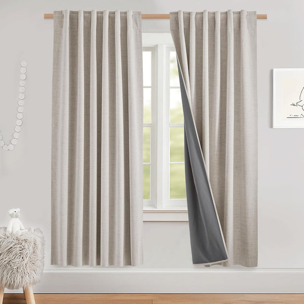 Beige textured blackout curtains with dark grey lining, hung on a wooden rod. Pleated top provides room darkening.