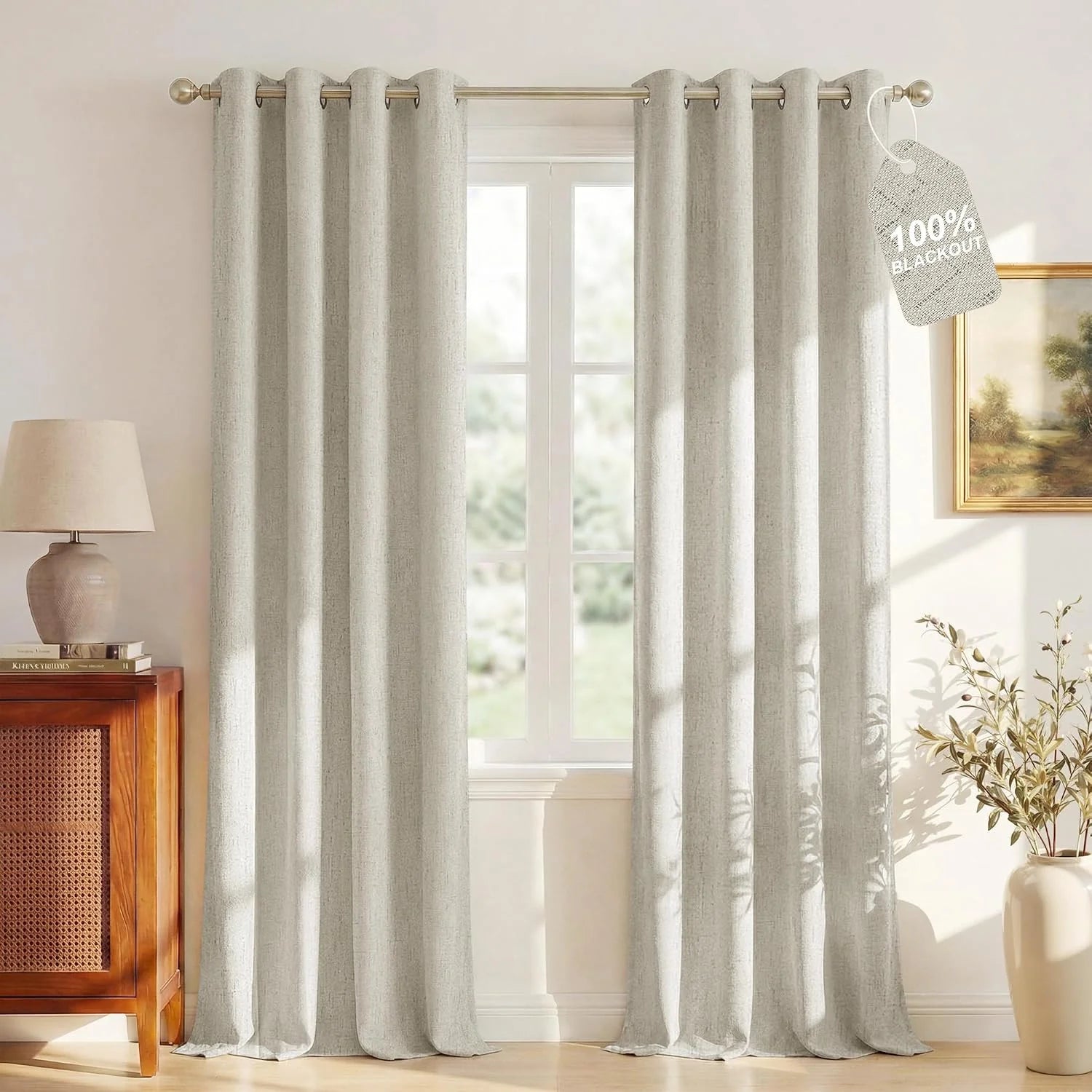 Beige textured blackout curtains with grommet top hanging in a bright neutral room