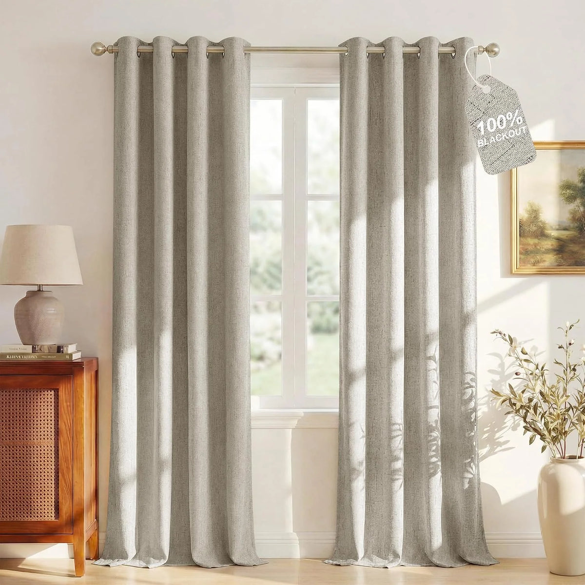 Beige linen-look blackout curtains with grommet top hanging in a bright living room