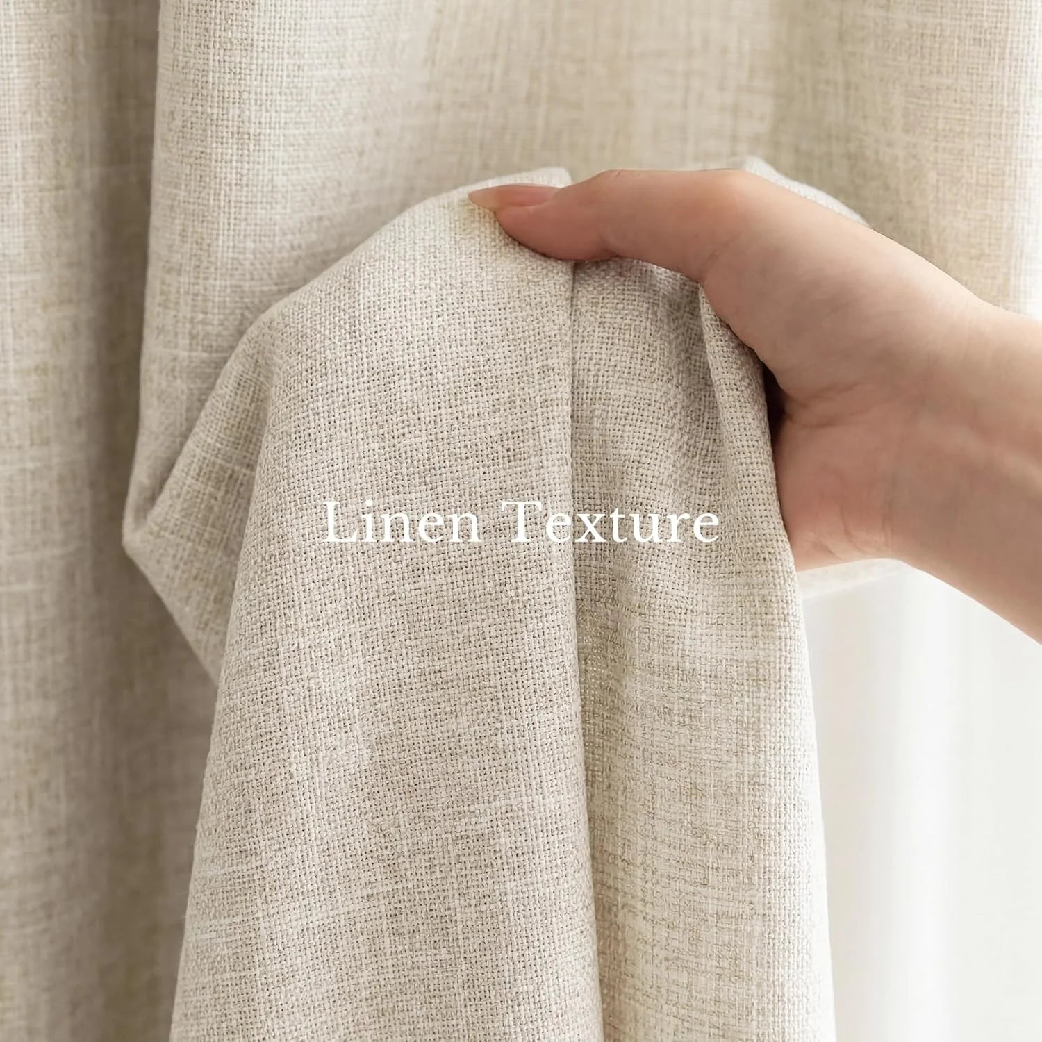 Close-up of a hand holding up a piece of beige linen-textured fabric, showing its natural weave.