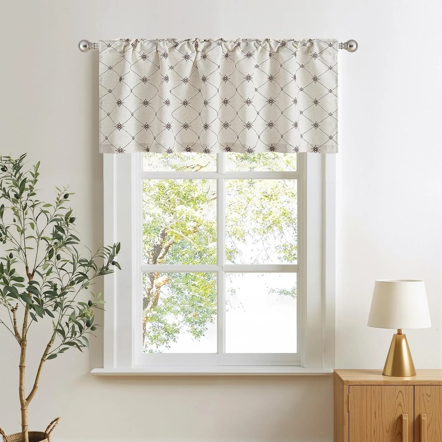 Beige linen-look window valance with brown geometric pattern on a white framed window