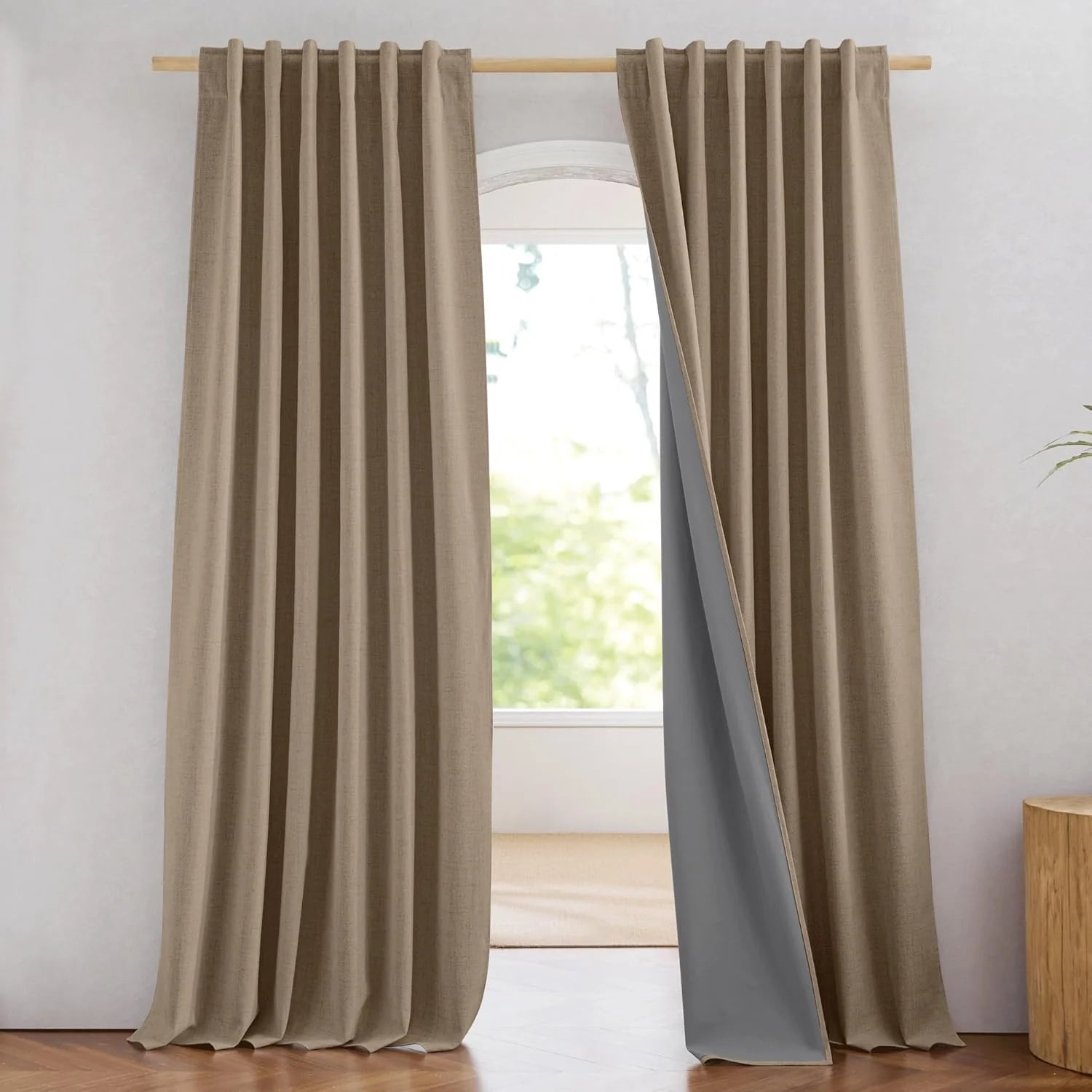 Beige linen-look blackout curtains with pleated header on a light wood rod