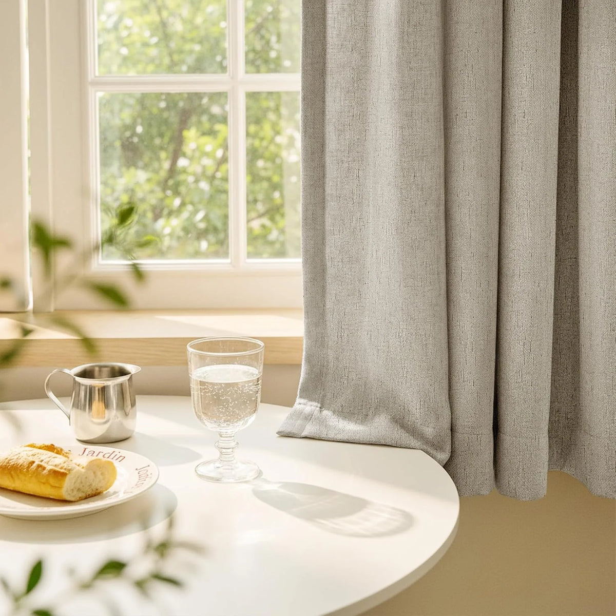 Beige linen-look curtains by a sunlit window above a white breakfast table
