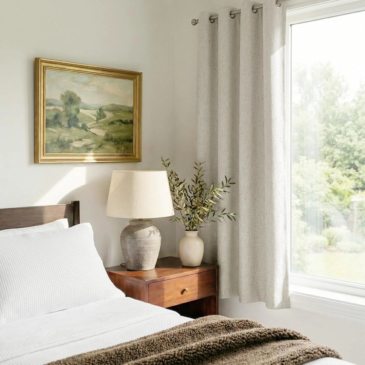 Beige linen-look grommet curtains beside a bright bedroom window with wood nightstand