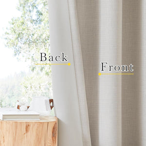 Light beige textured blackout curtains showing both woven front and smooth back layers, hanging by a sunny window.