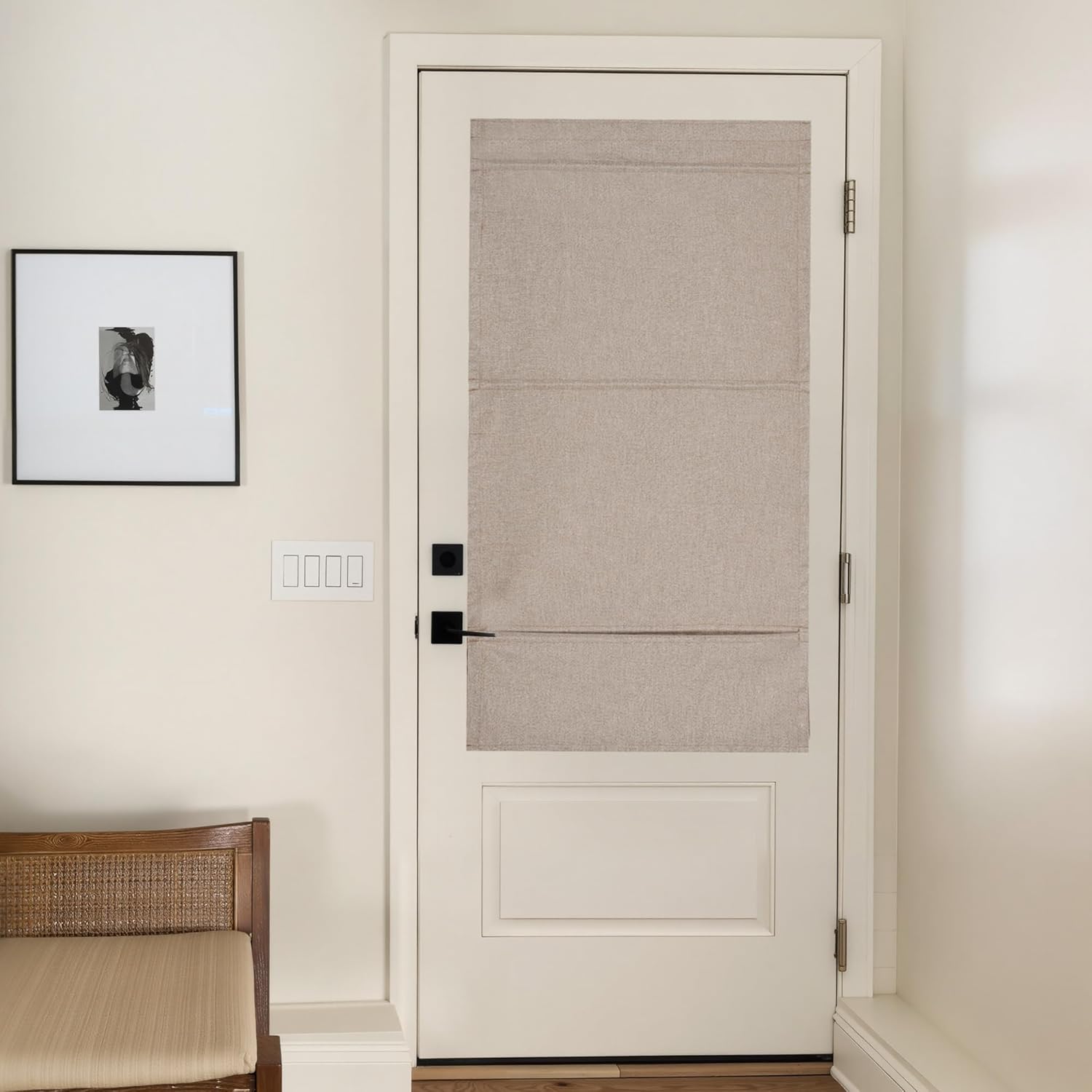 Textured beige linen roman shade covering the glass panel of a white door in a modern entryway.