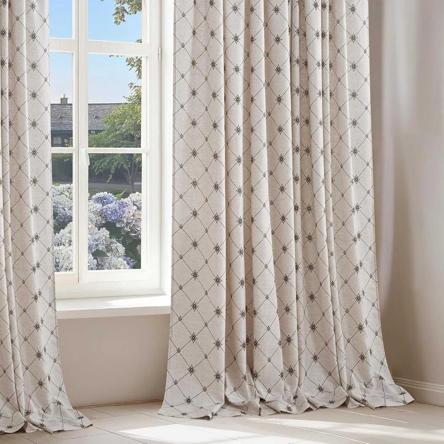 Beige linen-look curtains with brown trellis pattern hanging by a bright window