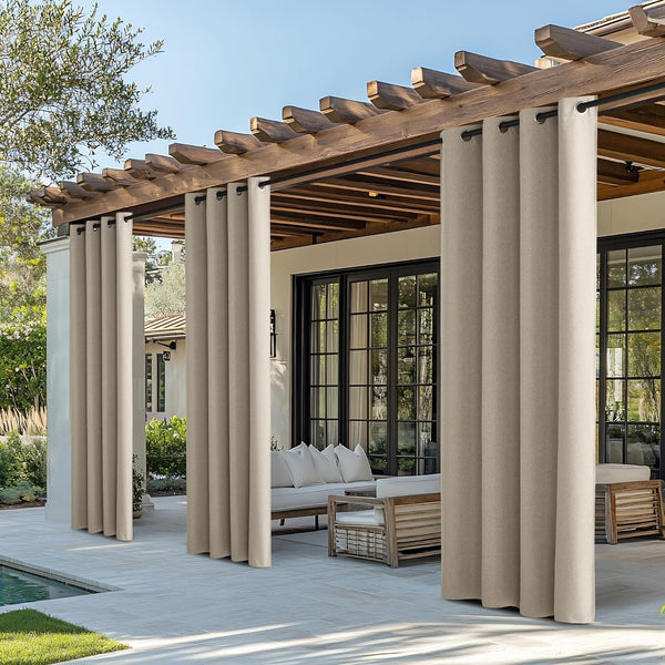 Beige outdoor patio curtains with black grommet tops hang from a wooden pergola, providing shade and privacy.