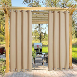 Beige outdoor curtains with grommet tops and bottoms hanging on a wooden pergola, creating a private patio space.