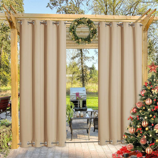 Two beige outdoor patio curtains with top and bottom grommets hanging on a wooden pergola.